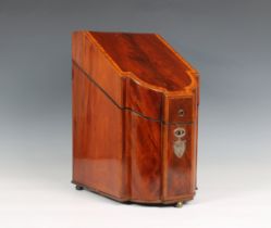 A George III mahogany knife box, of serpentine form, the hinged top inlaid, containing forty-seven k