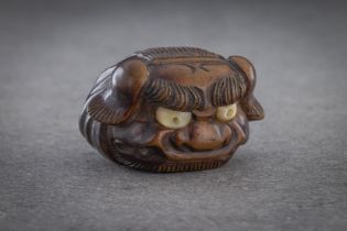 A WOOD MASK NETSUKE OF A SHISHI HEAD