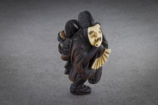 A RARE AND FINE WOOD NETSUKE OF AN OKINA DANCER