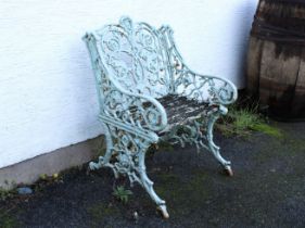 A Victorian painted cast iron garden seat with arms, in the manner of Coalbrookdale