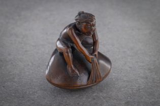 A WOOD SHUNGA NETSUKE OF MAN ON HAMAGURI CLAM