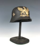 A trench art German helmet on stand