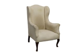 A vintage white upholstered wingback chair.