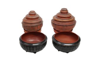 Two sets of Indian red lacquered papier mache interlocking footed bowls