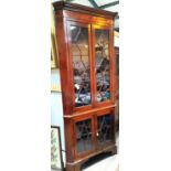 A Georgian mahogany floor standing corner cabinet with moulded cornice and inlaid frieze, enclosed