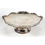 A shaped circular hallmarked silver fruit dish with scrolled border and pedestal base, Sheffield