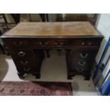 A mahogany desk with green writing insert, three drawers to each pillar and a central draw