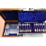 A cased set of six pearl handled knives and forks with etched grape on vine blades; a cased set of