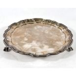 A Georgian-style circular hallmarked silver salver with wavy moulded border and three ball and