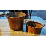 A large copper two handled bucket with rivet attached handles and another stamped made in Great