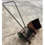 A vintage Greens push along rotary lawn mower