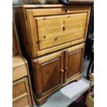 A modern pine side cabinet with fall front upper section and double cupboard below