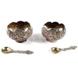 A cased pair of oriental lotus flower shaped white metal salts with extensive relief decoration of