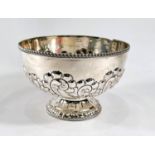 A hallmarked silver circular rose bowl on raised foot, with embossed scroll and shell decoration,