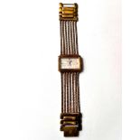 A lady's dress watch by Anne Klein, in gilt metal with 5 strand woven strap and 'lifetime' battery
