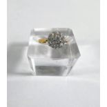 A lady's yellow metal dress ring with diamonds in flowerhead setting, central stone approx. 4mm