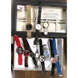 A selection of gents fashion watches and a watch storage case