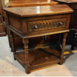 A reproduction 'credence' tale in distressed oak, with canted front and frieze drawer, on turned