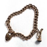 A yellow metal curb chain bracelet stamped '9c', with heart lock and trumpet charm, 12.9gm