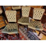 A set of six early 19th century dining chairs with deeply button back green upholstery, carved