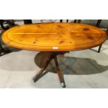 A nest of 3 yew wood trio tables; a similar oval coffee table