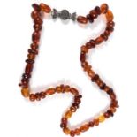 A faceted clear amber necklace of varying shapes and sizes of beads, with white metal clasp with