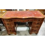 A reproduction pedestal kneehole desk in yew wood, with inset red leather top, frieze drawer and 8