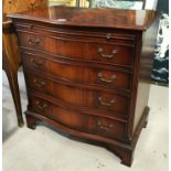 A reproduction mahogany bachelors chest with serpentine front, brushing slide and 4 graduating