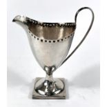 A Georgian classical-style helmet-shaped, hallmarked silver pedestal cream jug with punched border