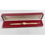 A lady's Omega 9 carat hallmarked gold wristwatch on 9 carat hallmarked gold bark effect bracelet,