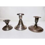 Three white metal short candle sticks with weighted bases, one stamped 830