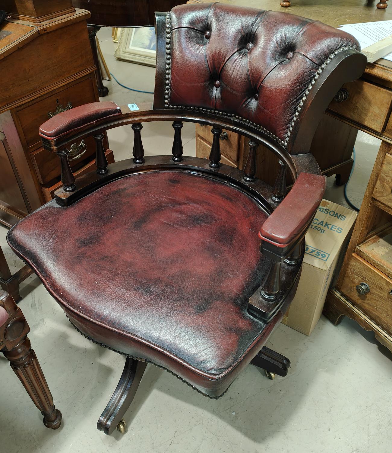 A red leather button back desk chair with studded decoration