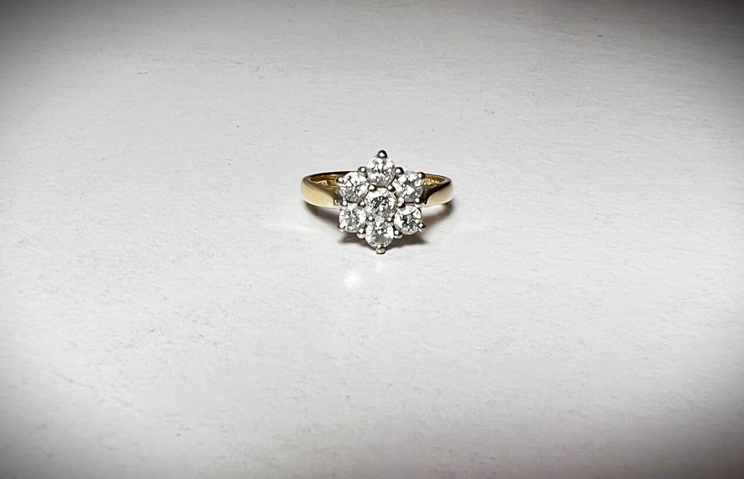 An 18ct hallmarked gold ring set with 7 diamonds in a flowerhead cluster, approximate diamond weight