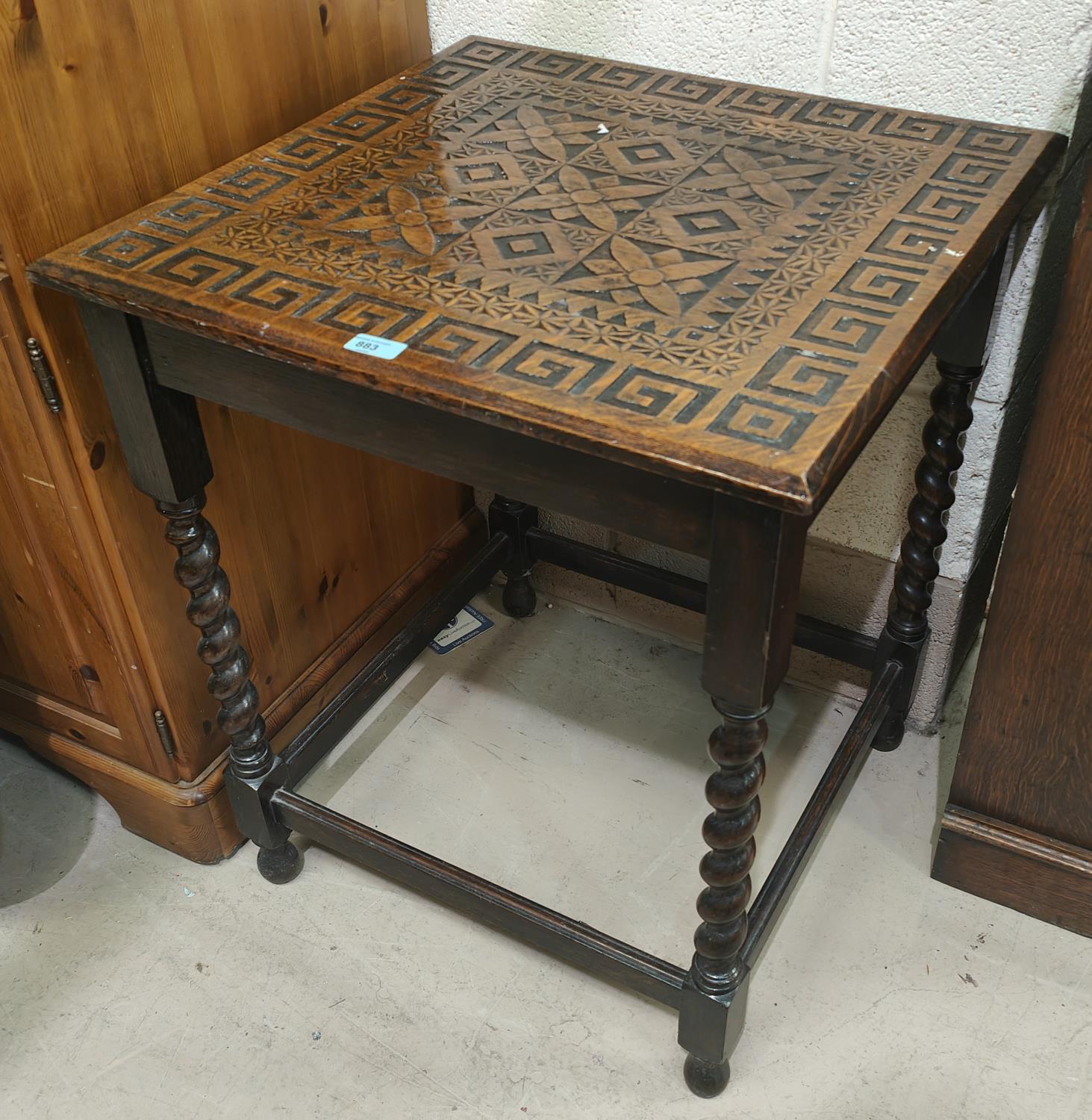 An early 20th century oak occasional table with geometric carving to the square top, on barley twist