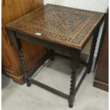 An early 20th century oak occasional table with geometric carving to the square top, on barley twist