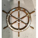 An ornamental ships wheel decorated with 59 world coins, 47 cm dia.;a similar frame and another