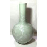 A Chinese celadon bottle vase decorated in white with birds on branches etc seal mark to base,