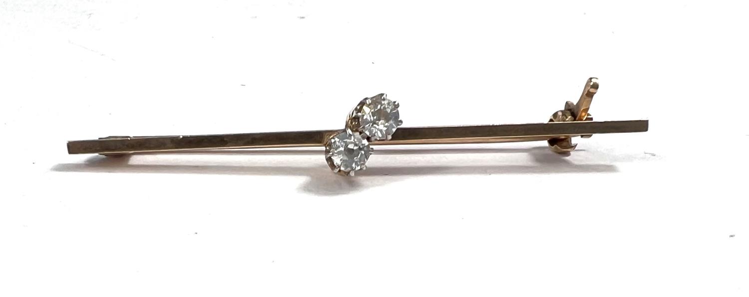 An Edwardian bar brooch stamped 9ct set 2 diamonds in crossover setting