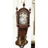 A reproduction Dutch wall clock in arch top oak case with painted arched dial, moon phase to the