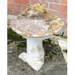 A reconstituted stone birdbath