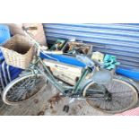 A vintage bicycle in green with basket to front