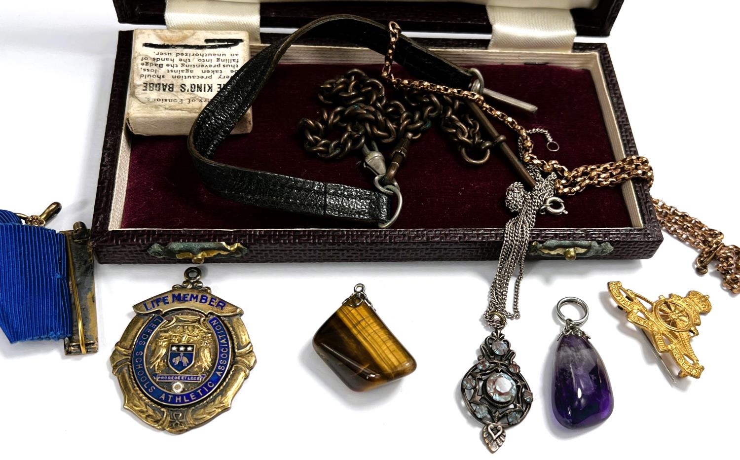 A silver gilt Leeds Schools Athletics medal, a military brooch and button, other pendants and