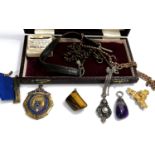 A silver gilt Leeds Schools Athletics medal, a military brooch and button, other pendants and