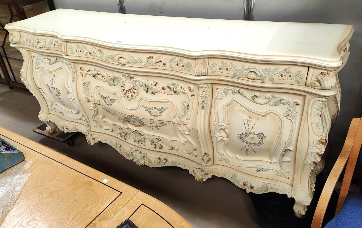 A large 18th century Italian style serpentine front commode with extensive floral and acanthus