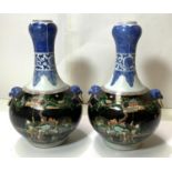 A pair of Chinese Famille Noir vases with blue and white highlights, traditional scenes with 6