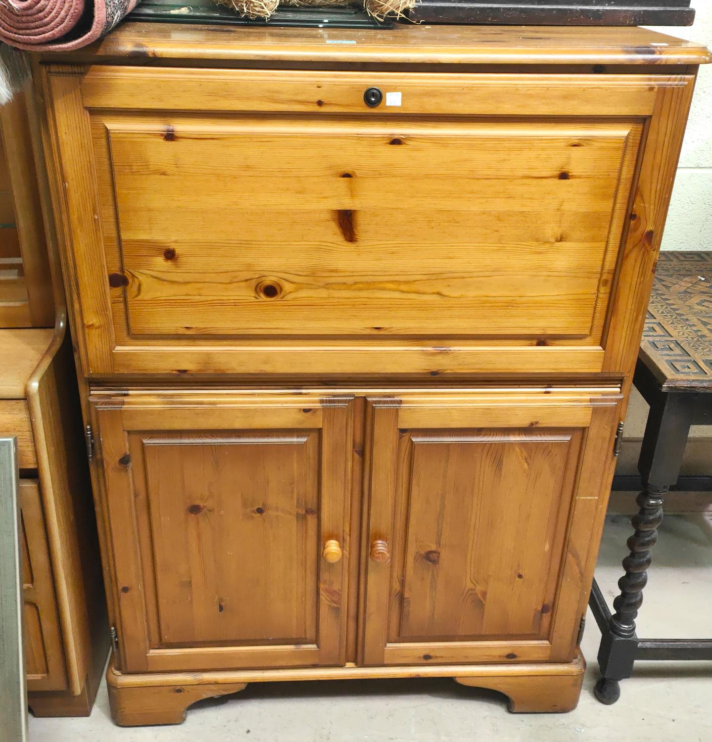 A modern pine side cabinet with fall front upper section and double cupboard below