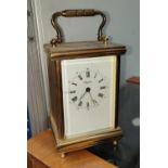 A brass quartz movement carridge clock with bevelled front glass enamel dial