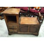 An oak Jacobean style telephone table with lion arm rest, hinged storage, two drawers and carved