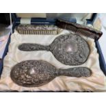 A silver embossed and cased 4 piece dressing table set