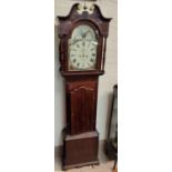 An early 19th century figured mahogany long cased clock, the hood with swan neck pediment and turned